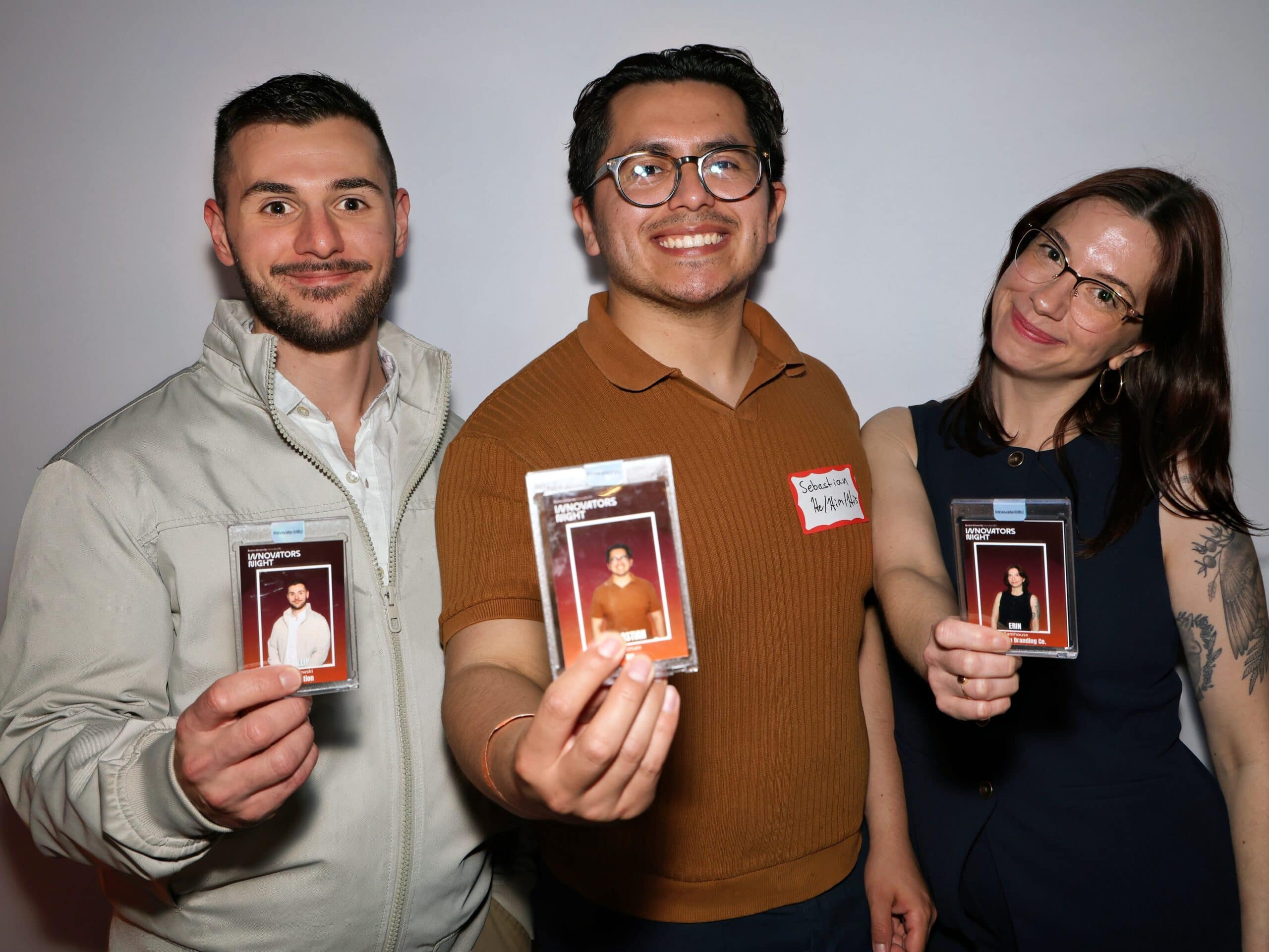Group of three individuals holding event badges at a celebration, showcasing personalized photo booth experiences, emphasizing interactive event services.