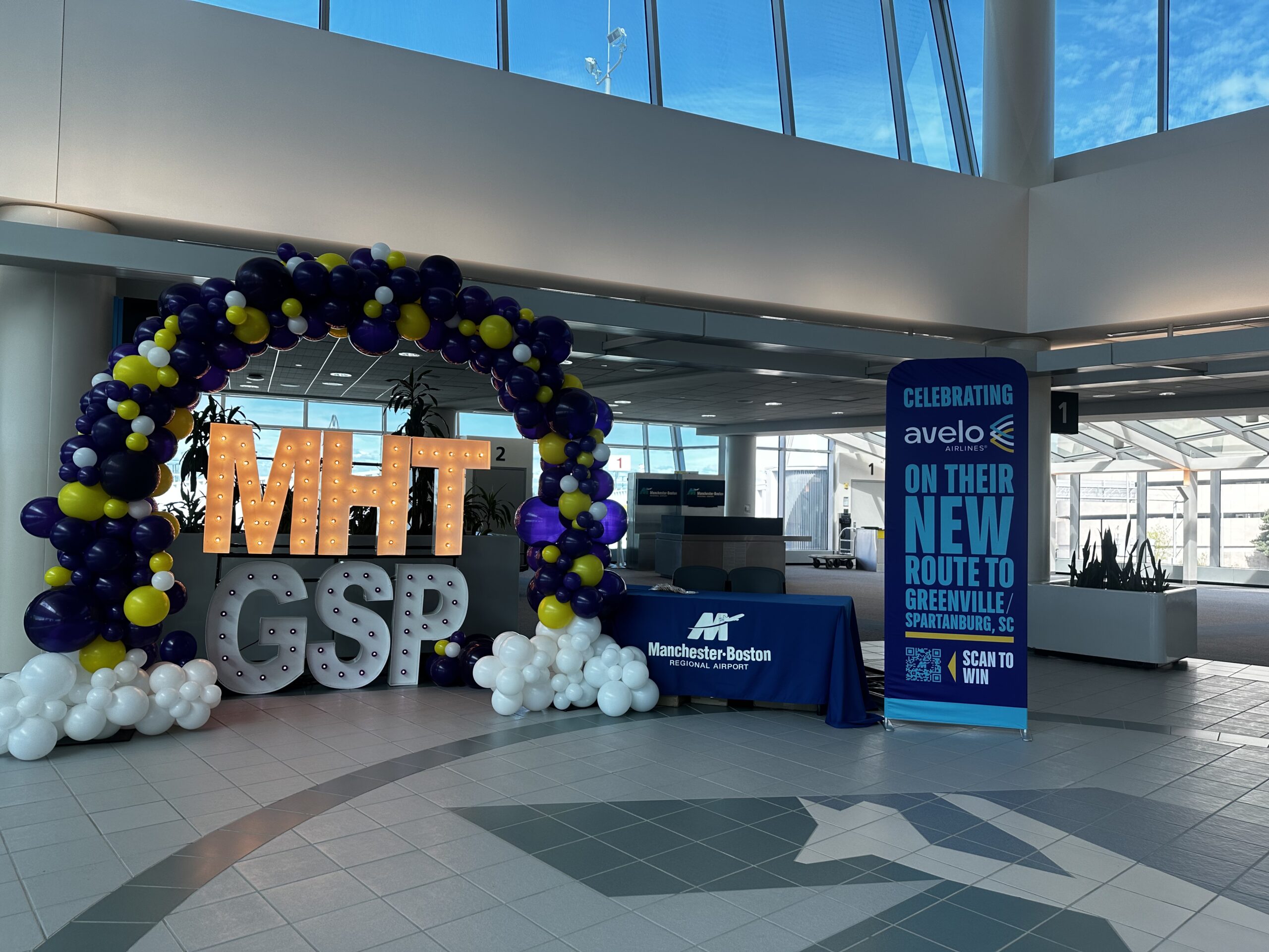 Balloon arch and marquee letter display at Avelo Airlines airport event celebrating a new flight route