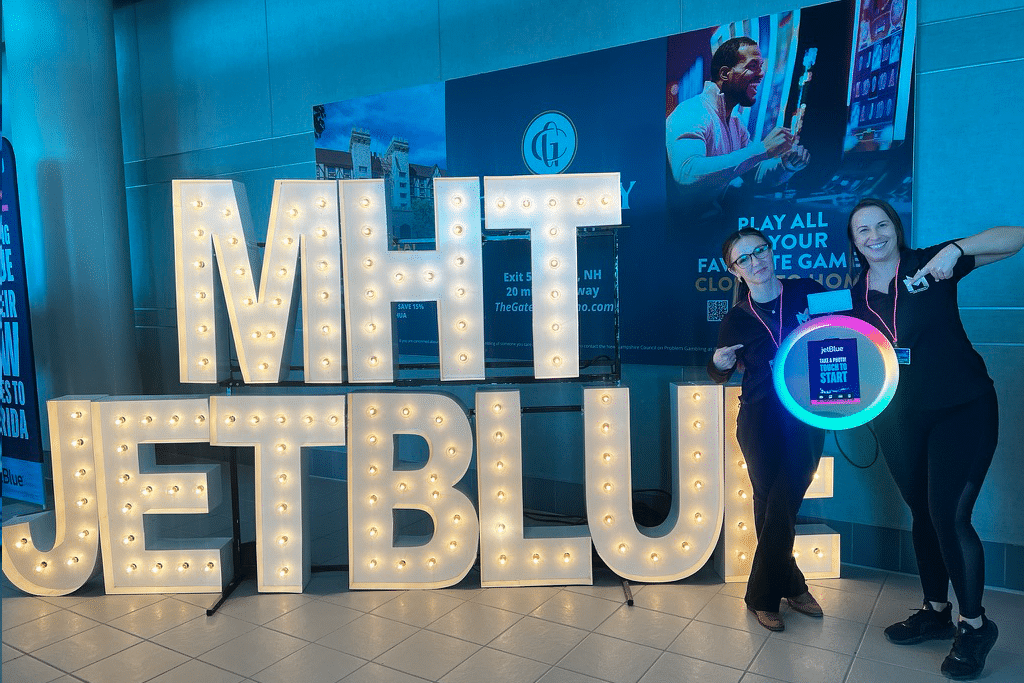 Woman posing next to LED ring photo booth and marquee letter display at JetBlue airport event