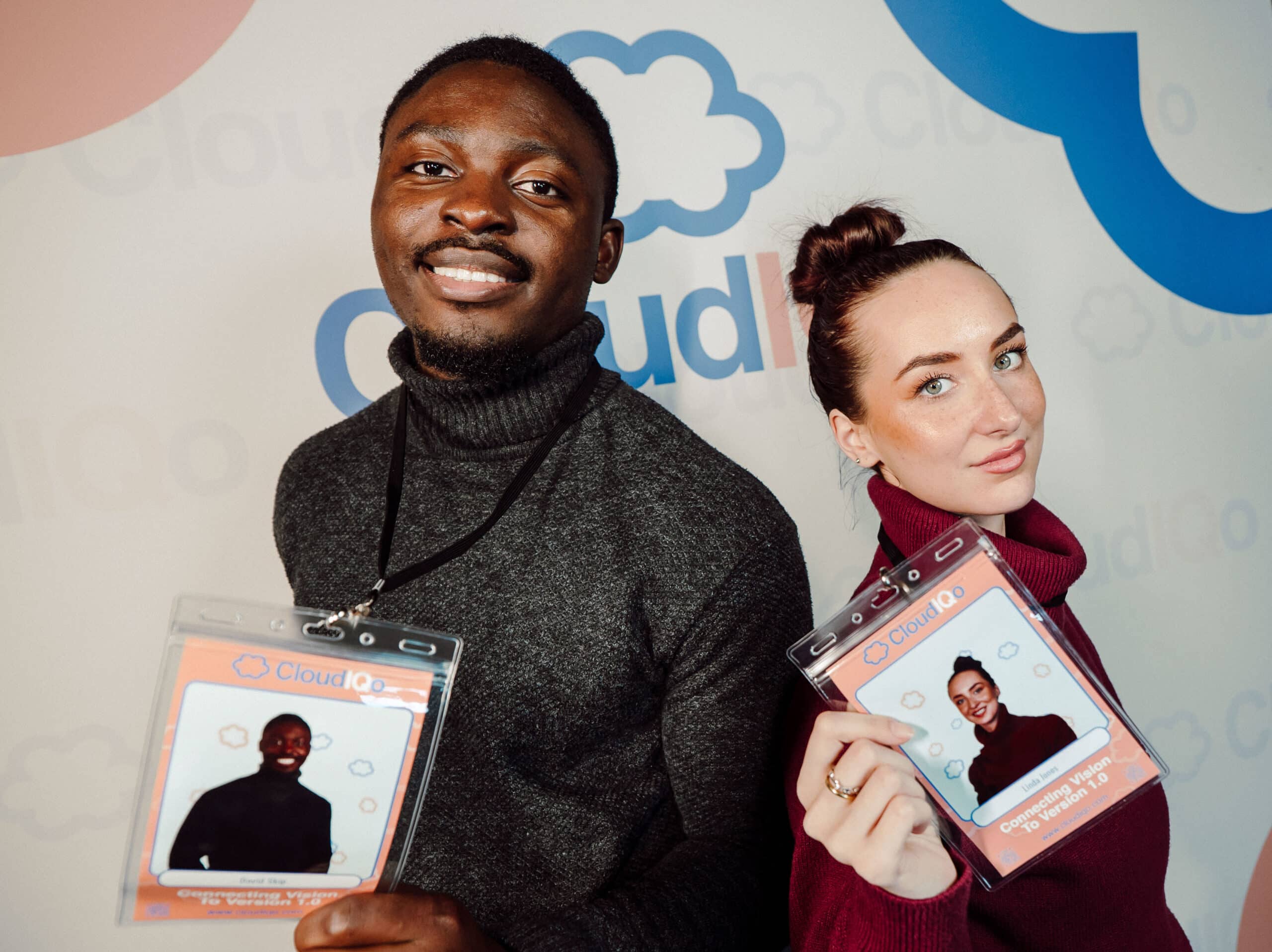 Two guests holding custom-printed event badges on lanyards from a Magic Mirror of New England photo booth experience